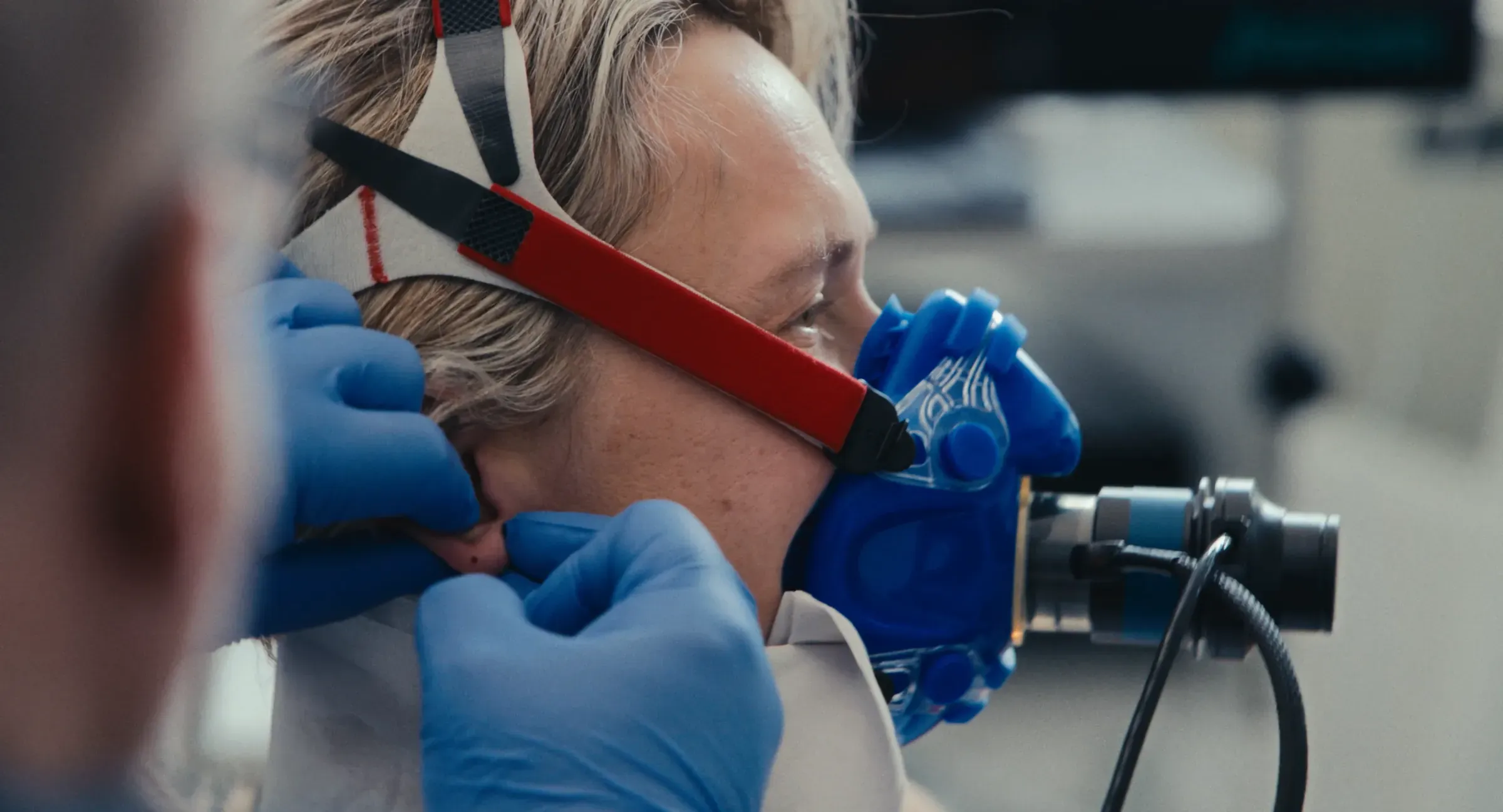 Film still from Breaking Barriers: a breathing mask being fitted during a performance test